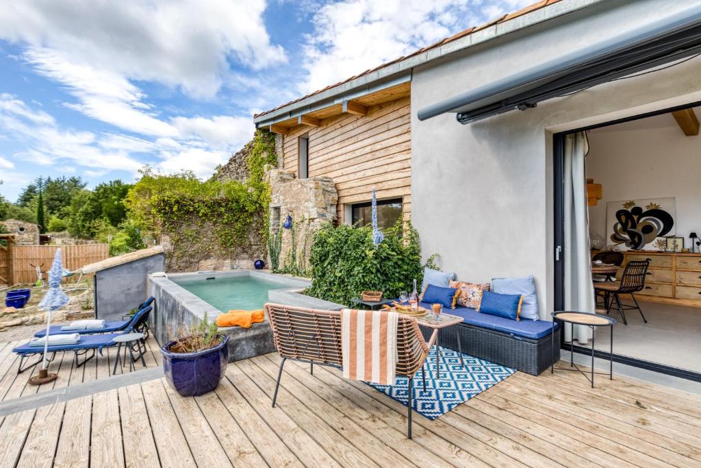 a patio with a pool and a table and chairs at Le Mas de Coeur in Bédarieux