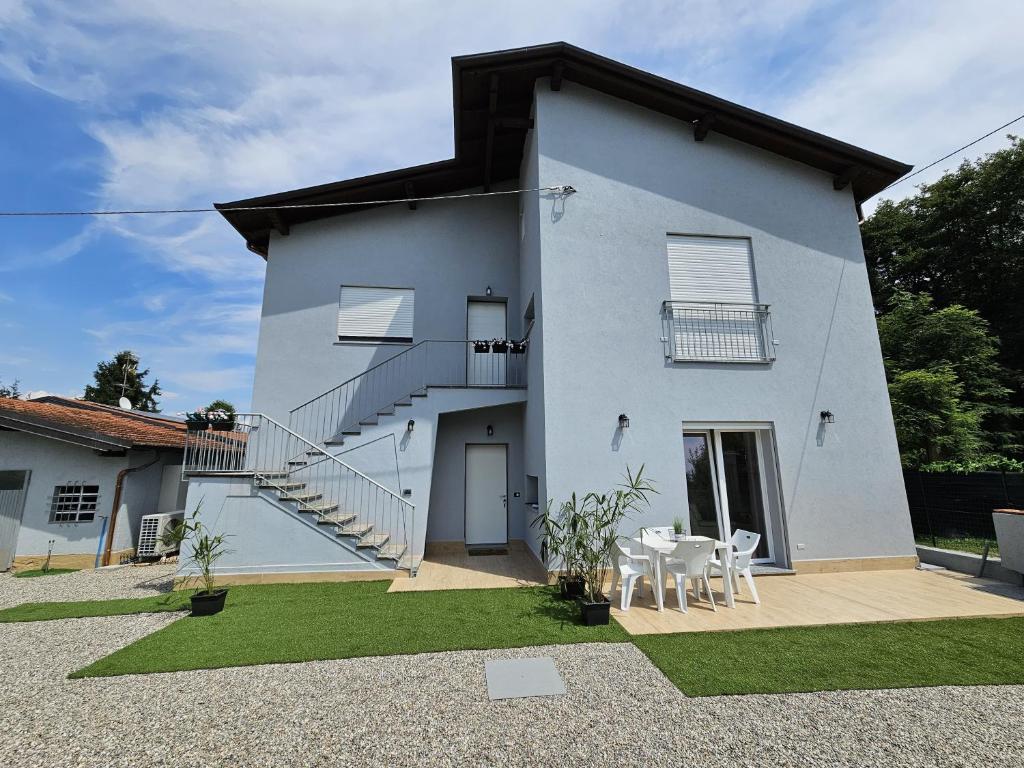 a white house with stairs and a table and chairs at Villa Lilia in Arona