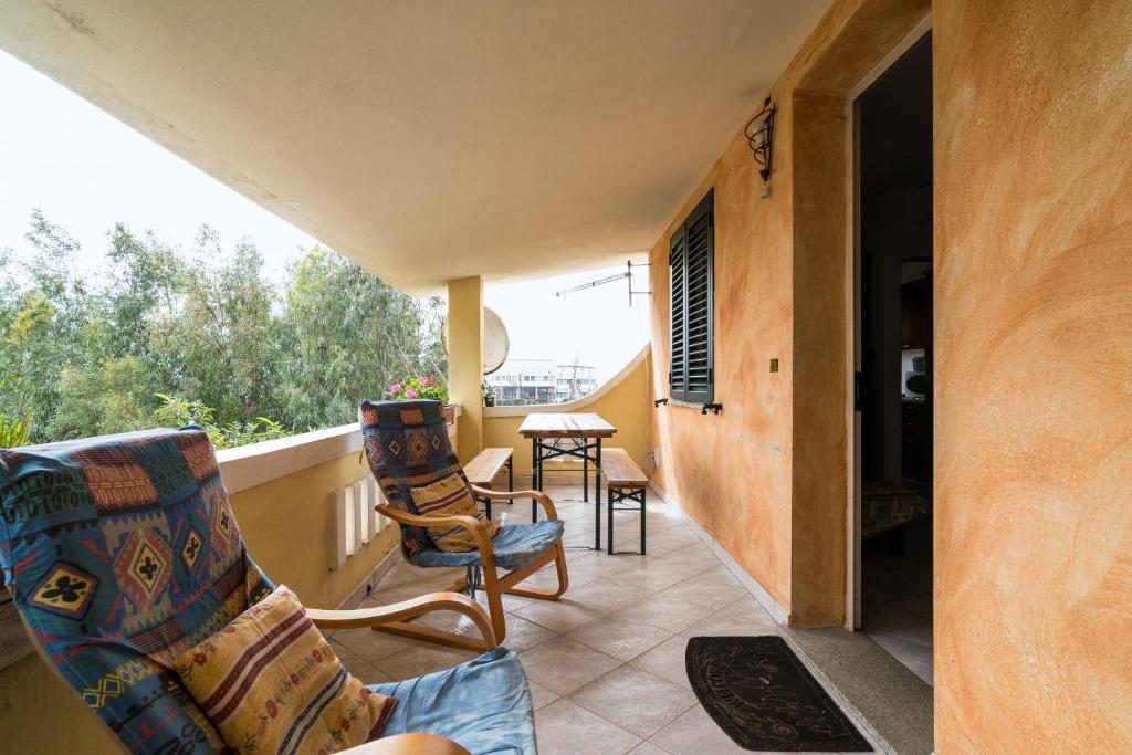 a porch with two chairs and a table on a balcony at Casa nel centro di Budoni in Budoni