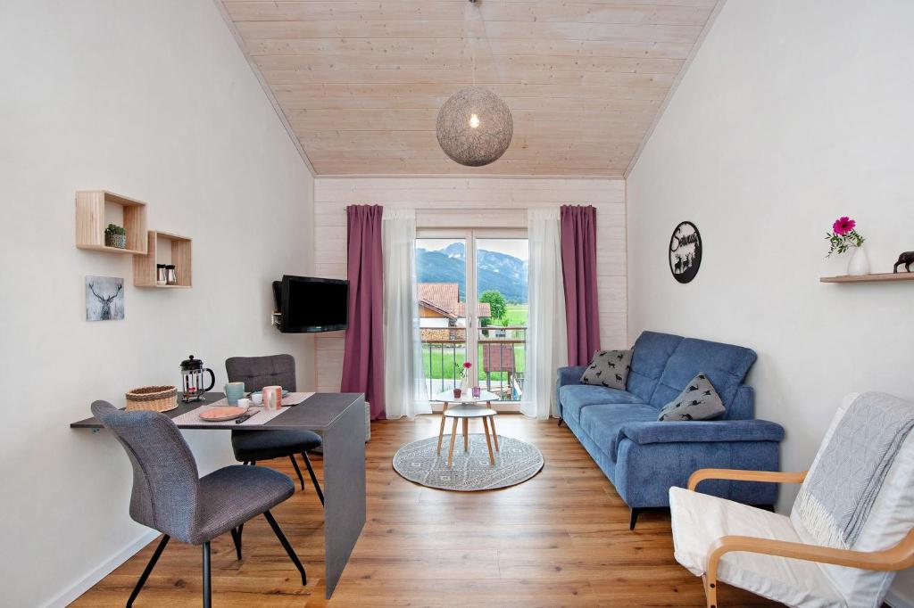 a living room with a blue couch and a table at Ferienwohnung Junge in Halblech