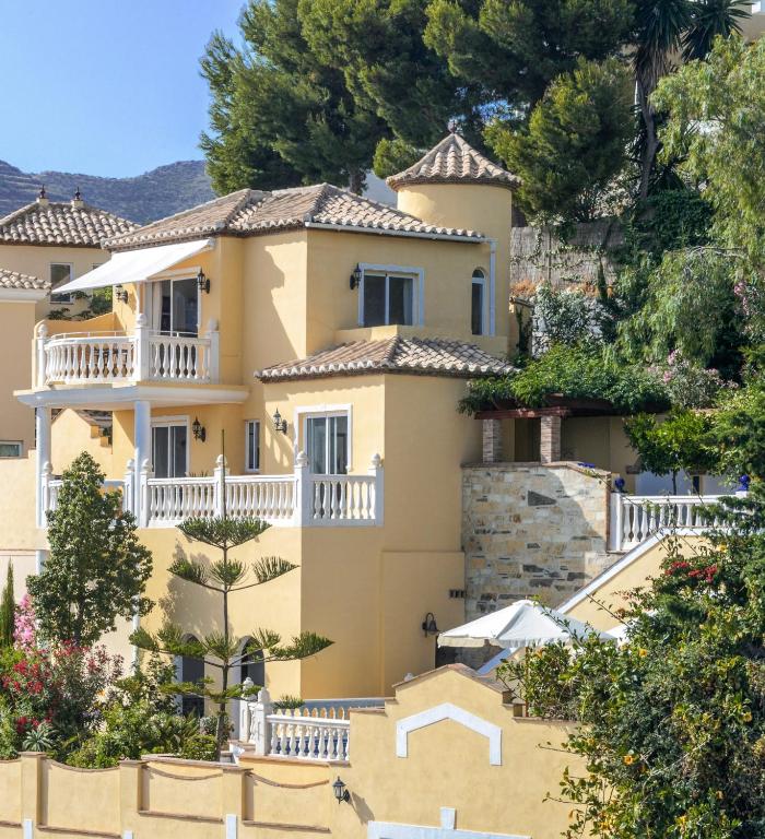 a large yellow house with white balconies at Villa Estrella de Cotobro in Almuñécar