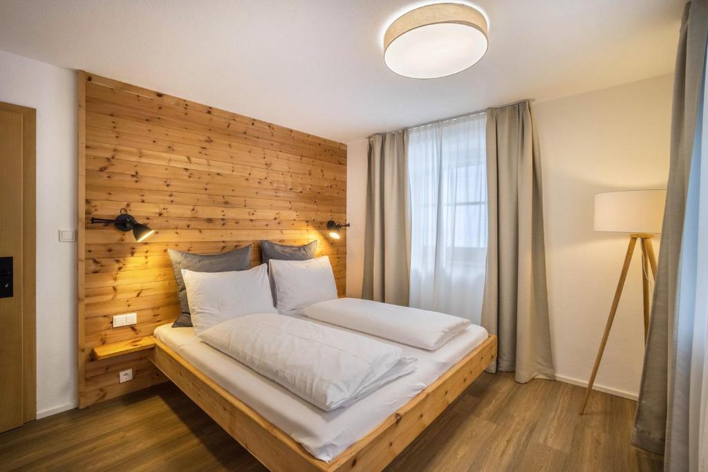 a bed in a room with a wooden wall at Mountain Residence Kasern Nr 2 in Predoi
