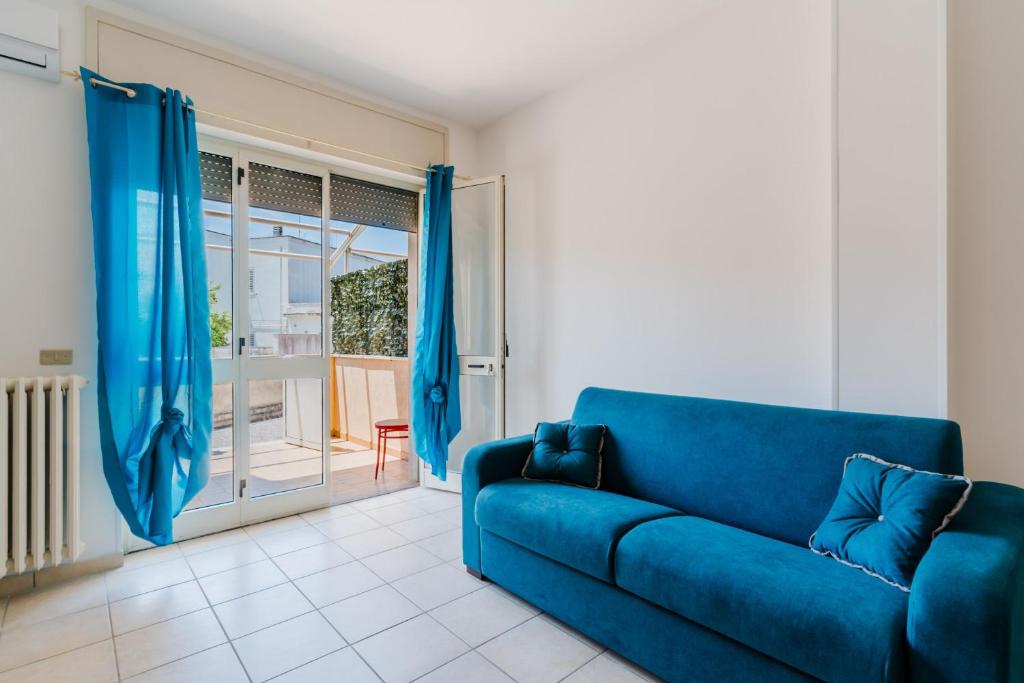a blue couch in a living room with a sliding glass door at Casa Giselle a Otranto in Otranto