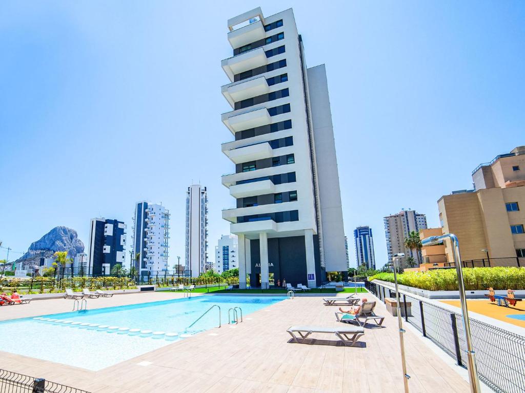a swimming pool in front of a tall building at Apartment Alexia by Interhome in Ifach