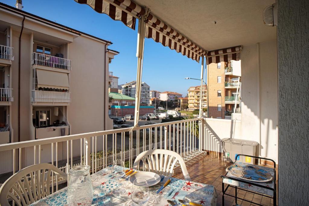 a balcony with a table and chairs on a balcony at Albenga Le Morelle 2 in Albenga
