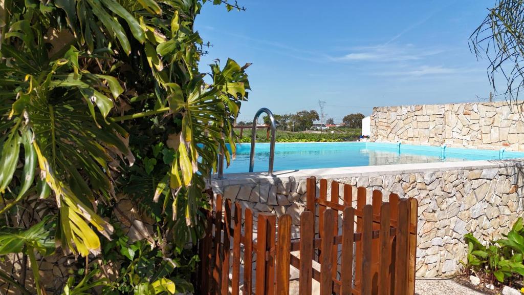 a wooden fence next to a swimming pool at Casa Arinto in Palmela