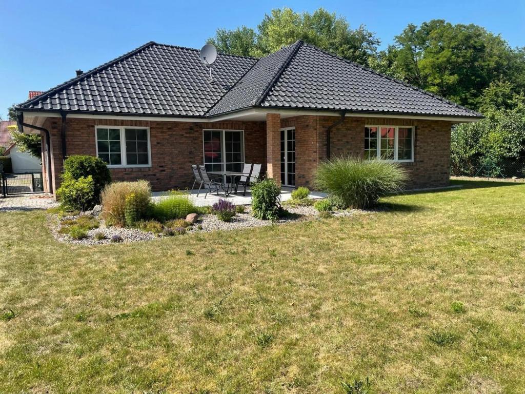 a brick house with a lawn in front of it at Ferienhaus Rechlin in Rechlin