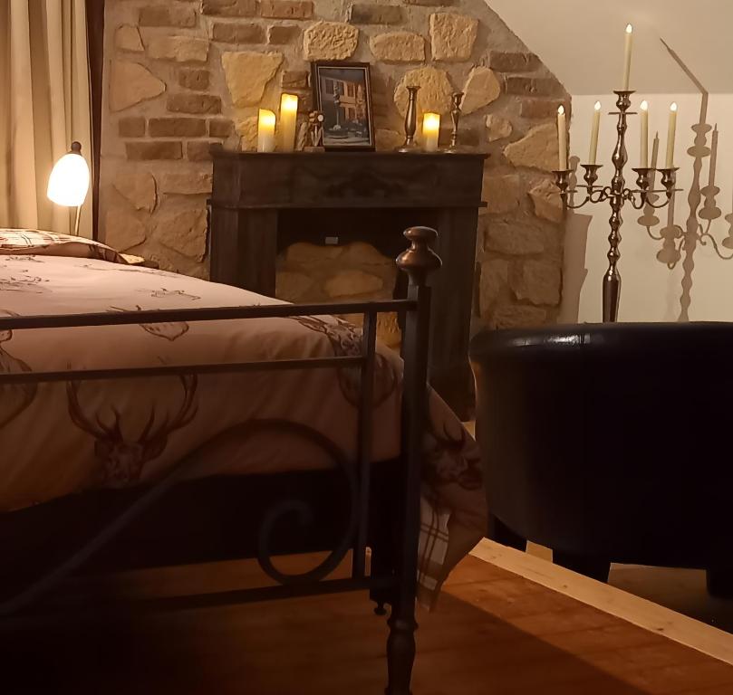 a bedroom with a bed and a fireplace with candles at Landhauswohnung Alte Mühle in Berlinghausen
