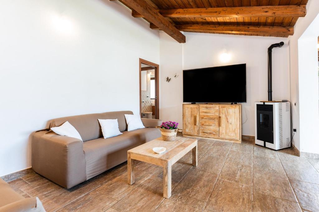 a living room with a couch and a flat screen tv at Villa Harmony in Quartu SantʼElena