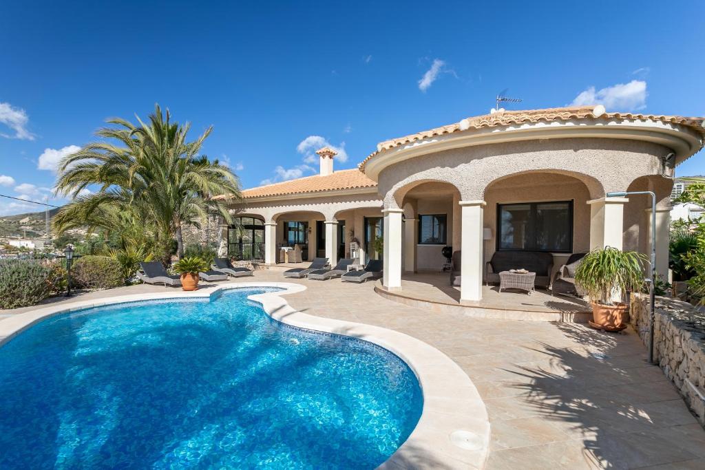 a villa with a swimming pool in front of a house at Villa Mara in El Campello
