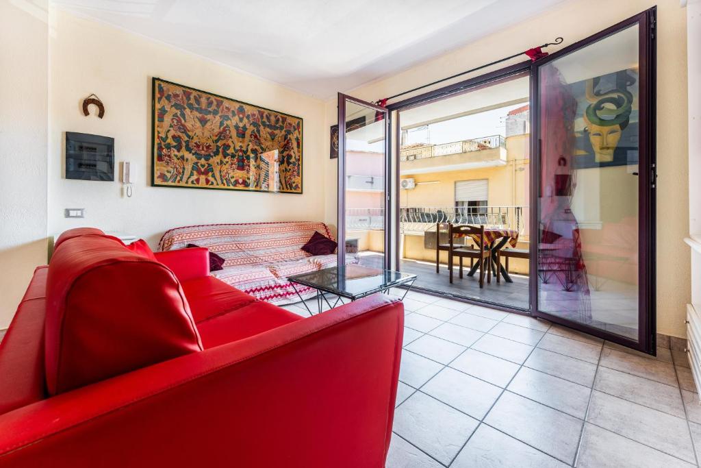 a living room with a red couch and a table at Magy House in Quartu SantʼElena