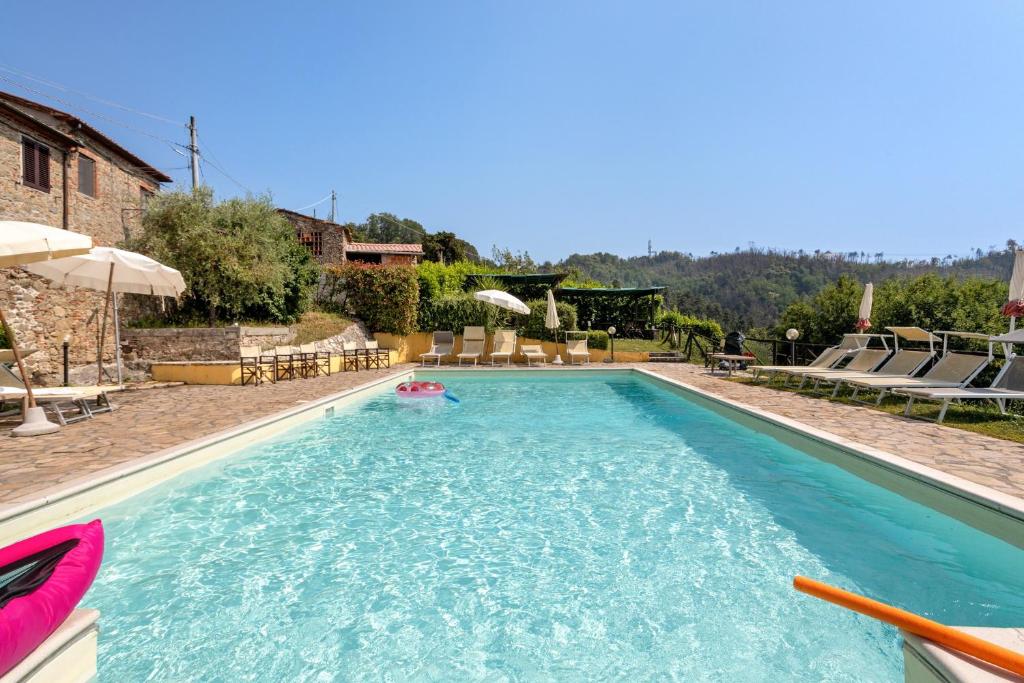 a large swimming pool with a pool noodle in a yard at Villa Chelucci - Gualdo in Massarosa