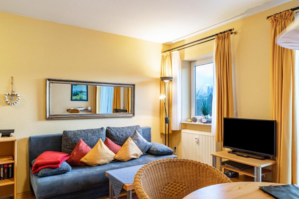 a living room with a blue couch with colorful pillows at Ferienwohnung Tannenblick 1-2 in Oberhof