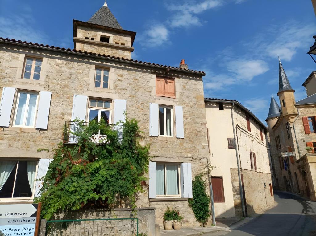 an old building with a tower on top of it at Maison L'oustal Du Lévéjac in Saint-Rome-de-Tarn