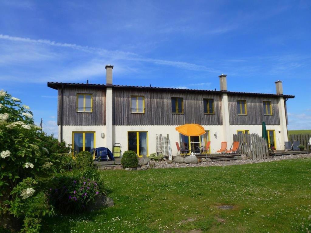 a large house with a green lawn in front of it at Ferienhaus Poggenkrug Halbsguth in Wolgast
