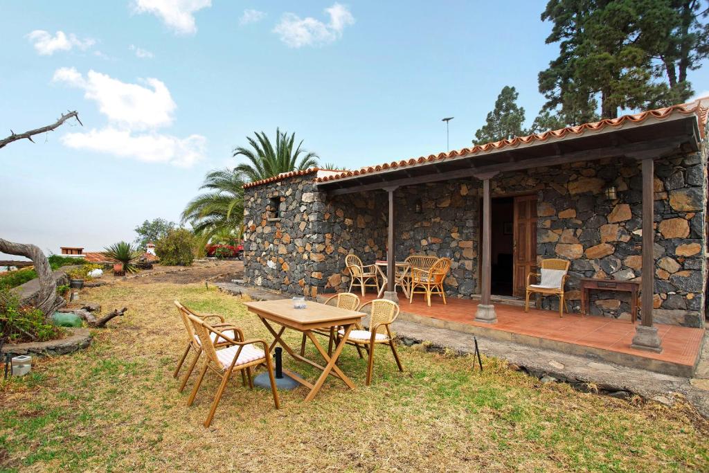 a stone house with a table and chairs outside at La Roquina in Tijarafe