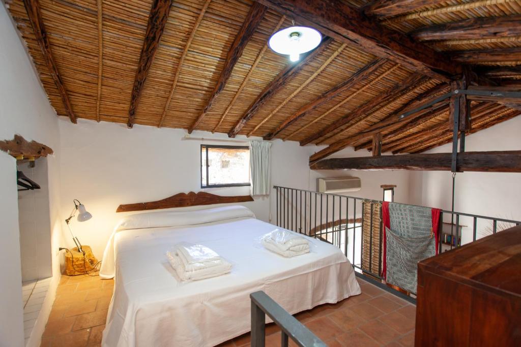 a bedroom with a bed in a room with wooden ceilings at Hora Hora in Orosei