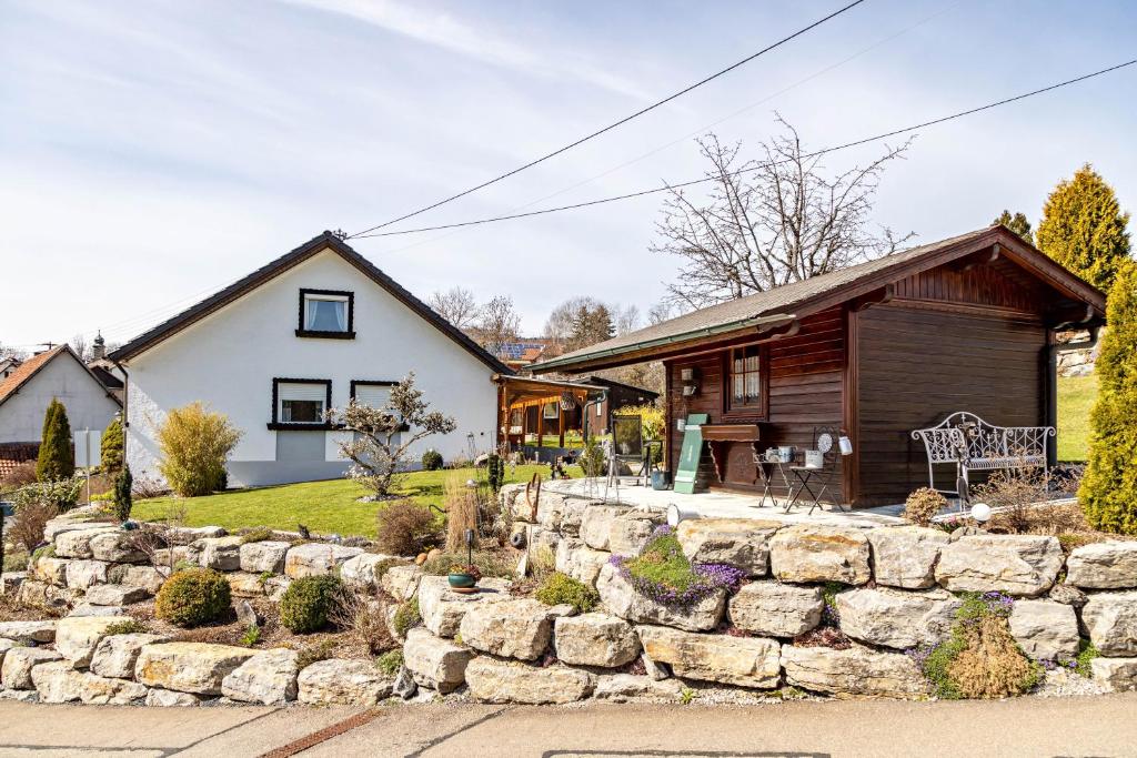 a home with a stone retaining wall and a house at Haus Elfi in Hausen am Tann