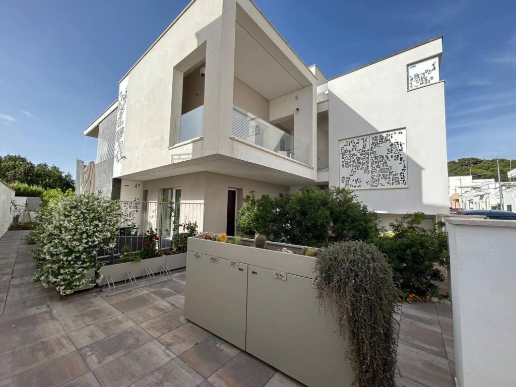 a large white house with a balcony on a patio at Lungomare Santa Caterina in Nardò