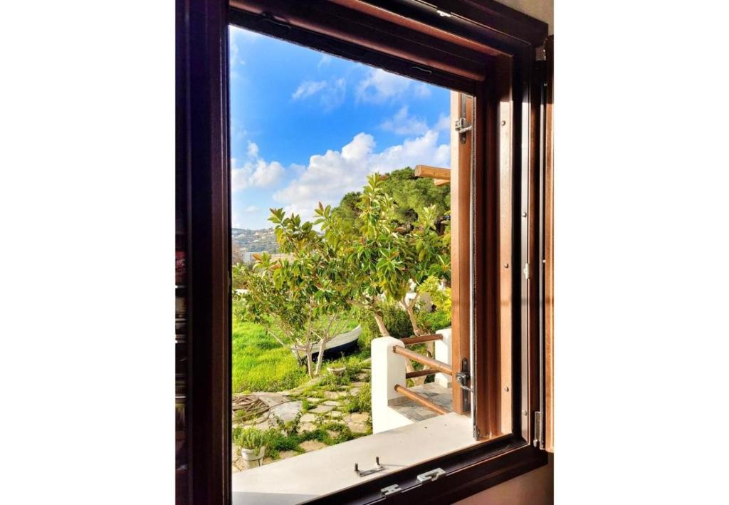 a window with a view of a garden at Villa Two Pine Trees in Alinda