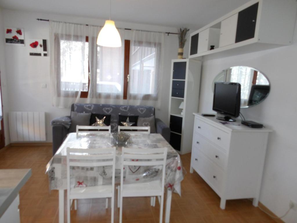 a small living room with a table and a tv at studio la joue du loup in Le Dévoluy