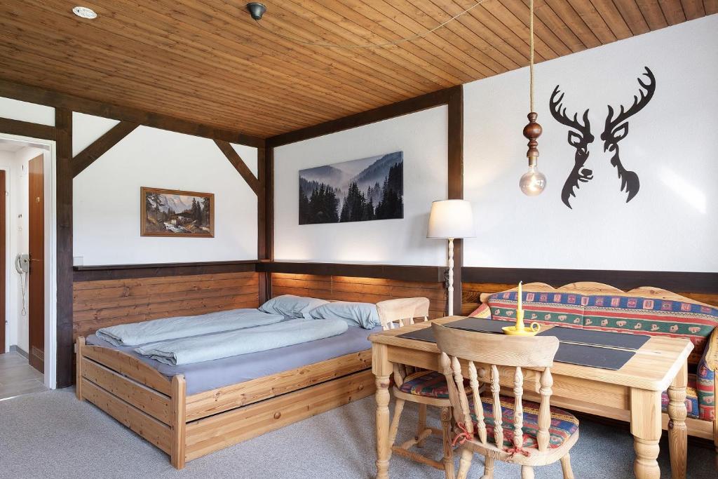 a bedroom with a bed and a table with a desk at Appartment Auszeit in Schönwald