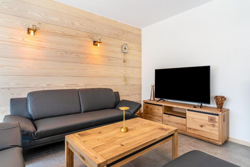 a living room with a couch and a flat screen tv at Im Rosengarten 2 in Zell am Harmersbach