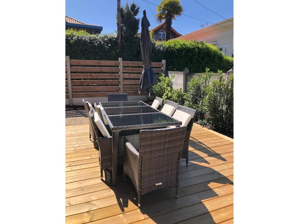 a table and chairs with an umbrella on a deck at Rayon de soleil Arcachon in Arcachon