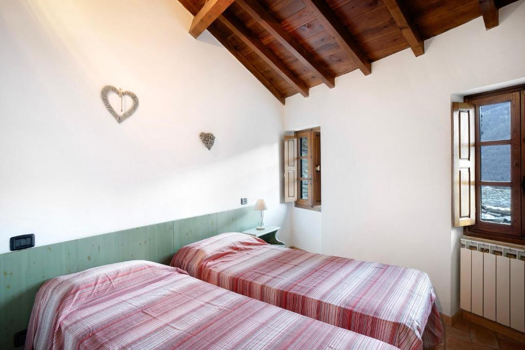 two beds in a room with white walls at Casa Verde - Sciu´ Pepin in Rezzo