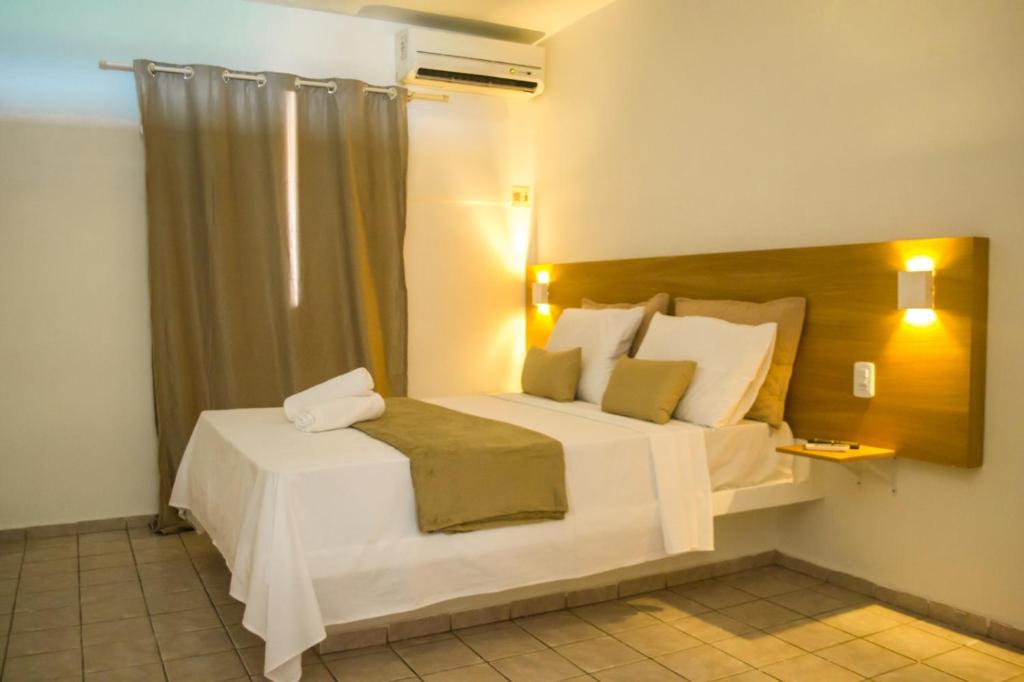 ein Schlafzimmer mit einem großen weißen Bett in einem Zimmer in der Unterkunft Hotel Pousada Sol Beira-mar in Natal