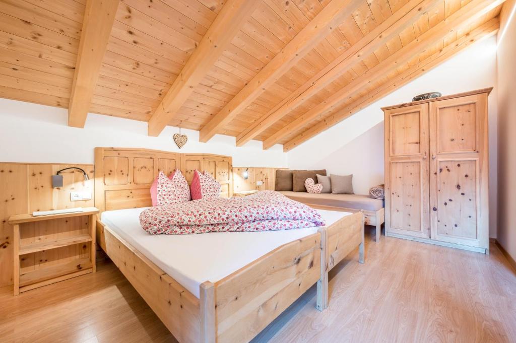 a bedroom with a large bed and a wooden ceiling at Raffreiderhof Apt Zirbe in Luson