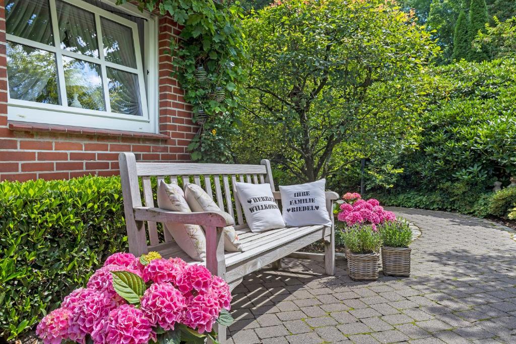 a wooden bench with pillows on it next to flowers at Ferienwohnung Riedel in Sundern