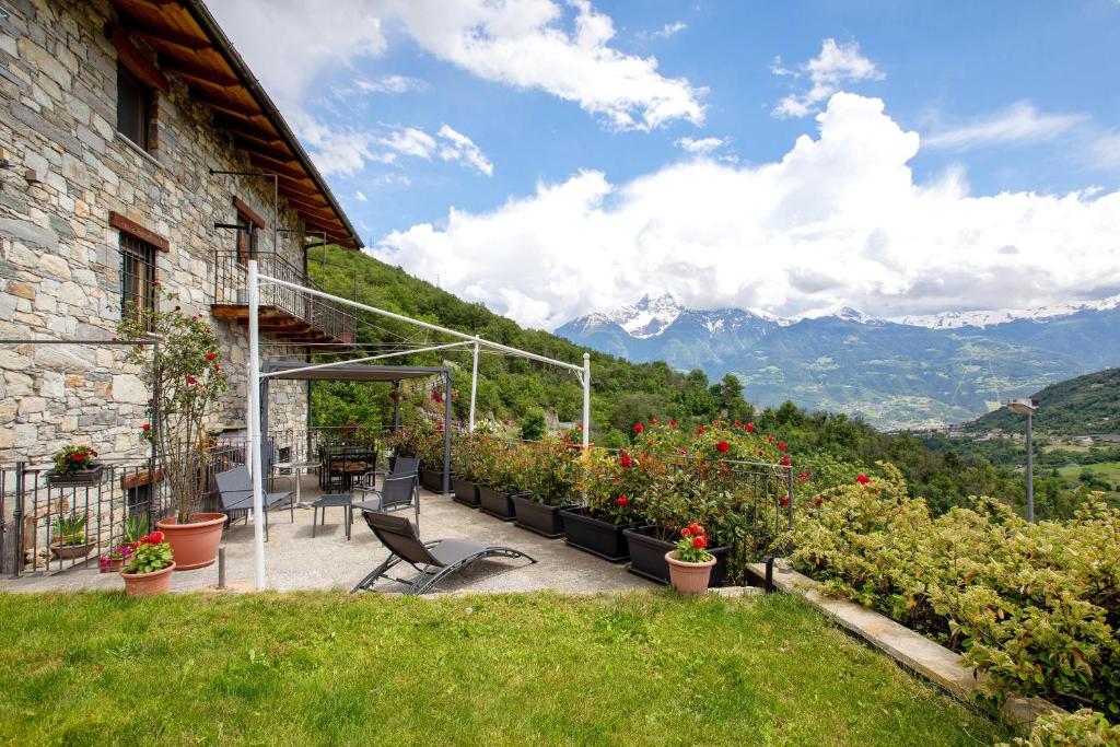 a patio with a chair and flowers and a building at La Casa Di Pasky in Roisan