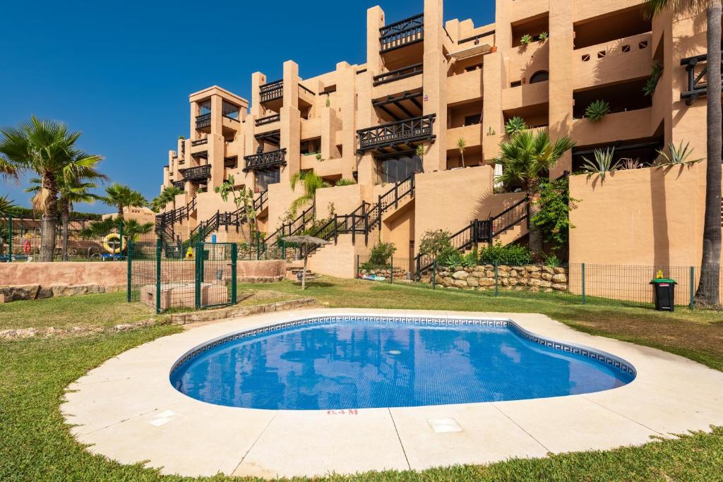 a swimming pool in front of a building at Apartment Coto Real in Manilva