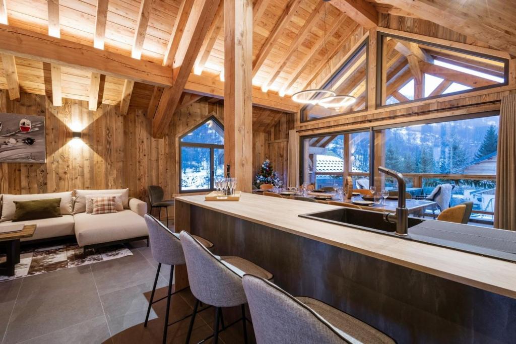 a kitchen and living room in a log cabin with a sink at Chalet-Spa Le Cervin in Valloire
