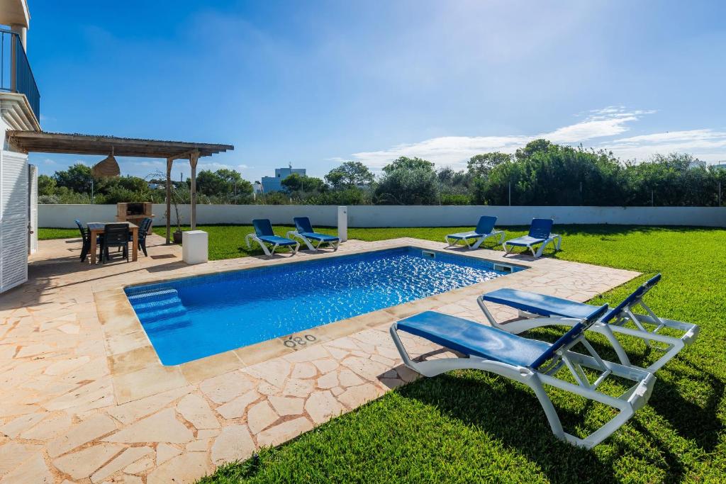 a swimming pool with lounge chairs and a table at Ca na Magdalena in Santanyi