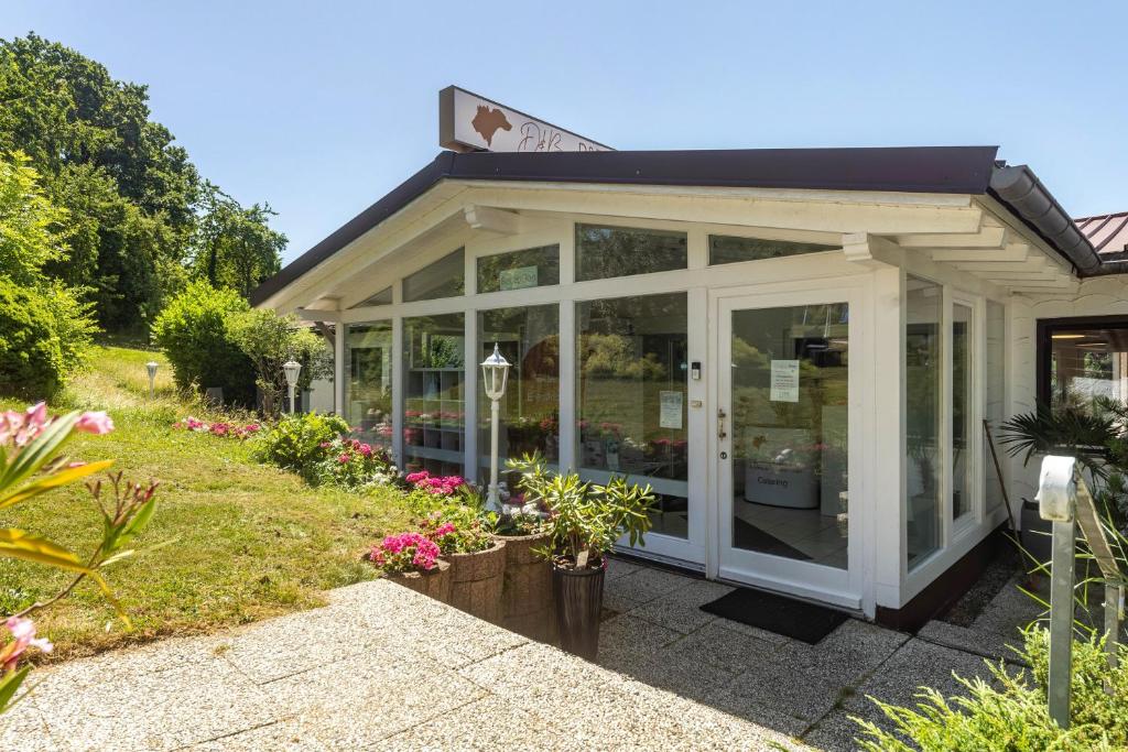 a greenhouse with glass doors in a garden at db Staycation Ferienpark in Niedenstein