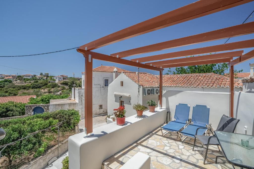 a patio with two blue chairs on a roof at Angel’s studio in Potamós