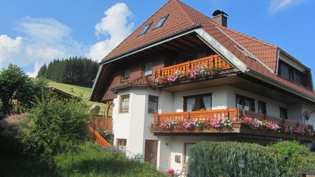 a house with a balcony with flowers on it at Ferienhaus Brigitte - Breitnau in Breitnau
