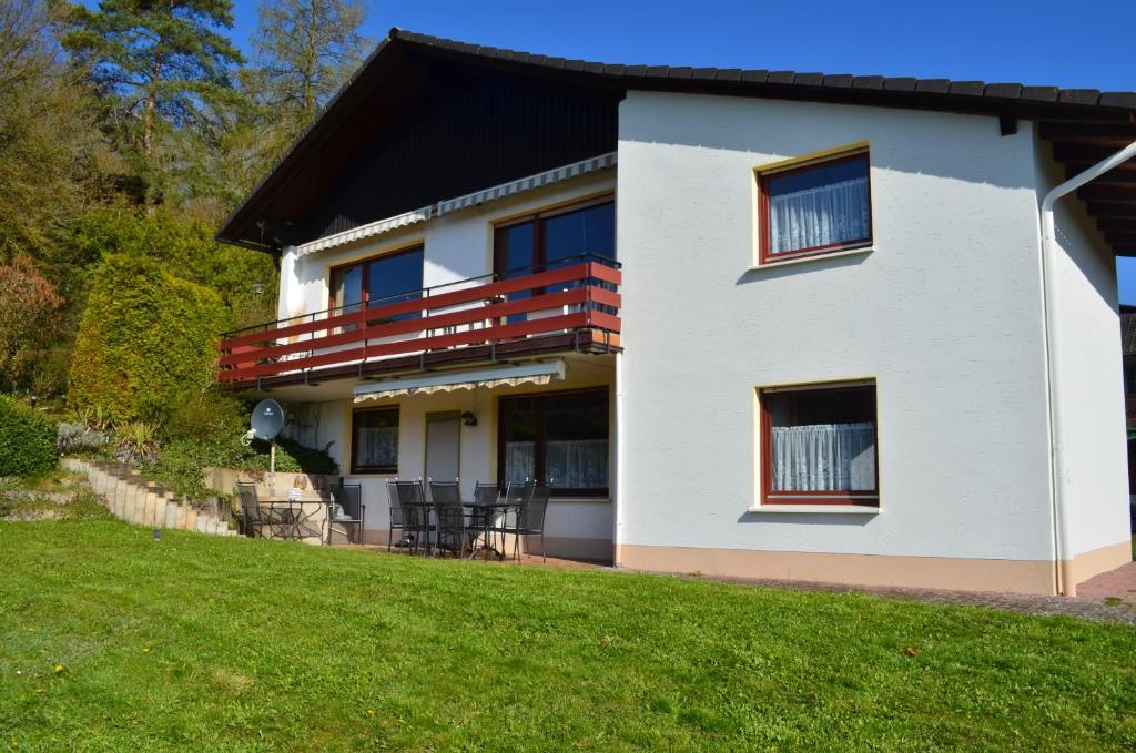a white house with a balcony and a lawn at Am Trapp in Padberg