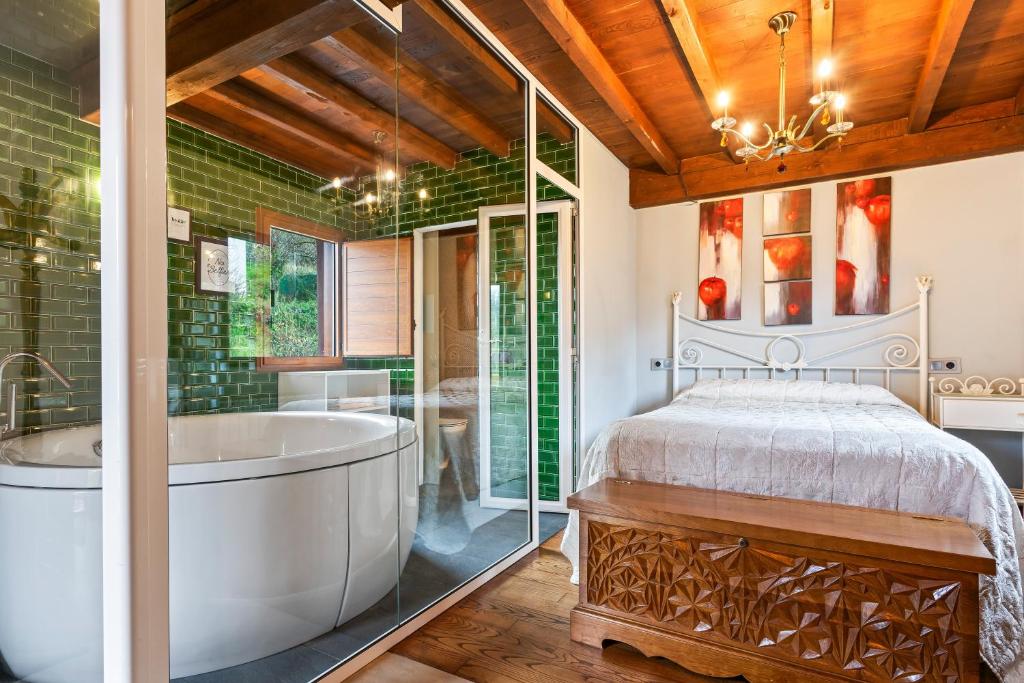 a master bedroom with a tub and a bed at La Manzana in Candamin