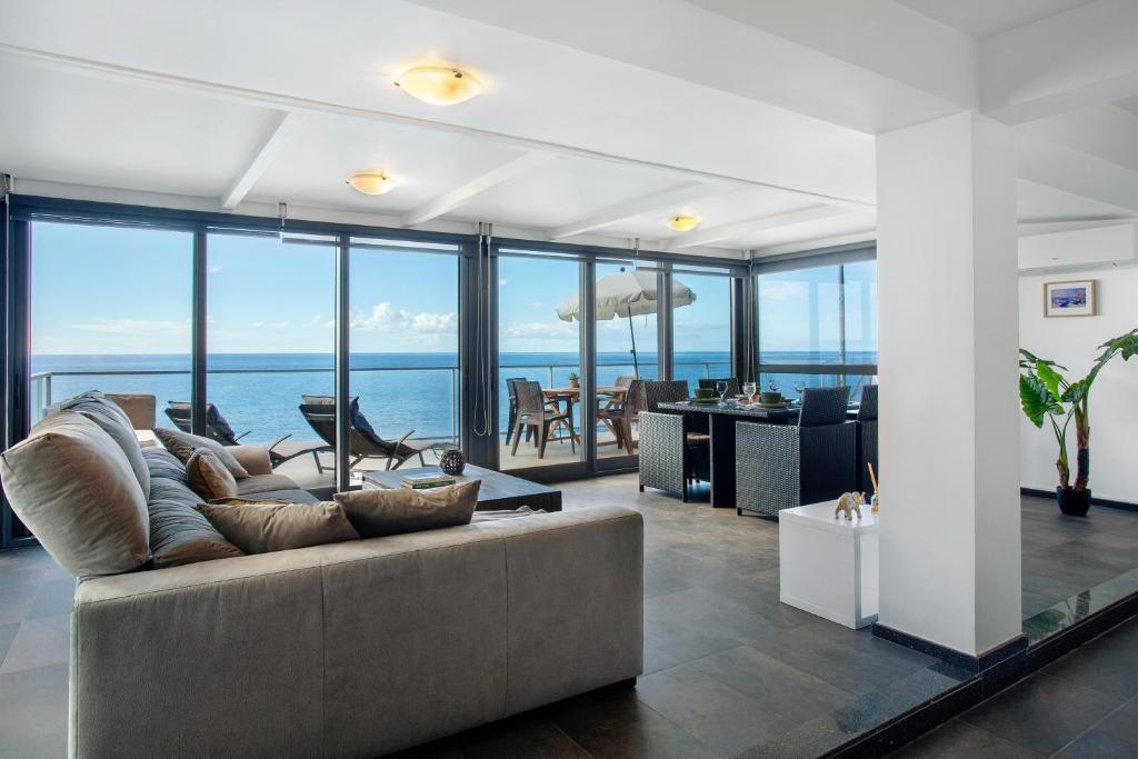 a living room with a couch and a view of the ocean at The Wave House - Seaside Haven in Jardim do Mar