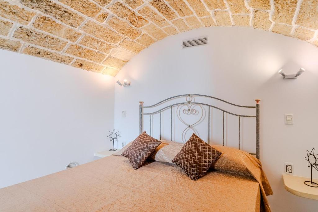 a bedroom with a bed and a brick wall at Elena Inn in Matino