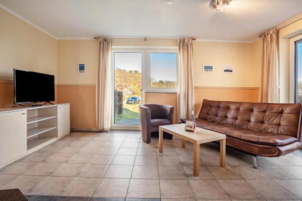 a living room with a couch and a tv and a table at Habichtssicht in Buschvitz