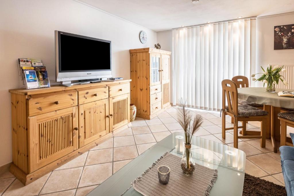 a living room with a flat screen tv on a wooden cabinet at Schwarzwaldblick in Sankt Georgen im Schwarzwald