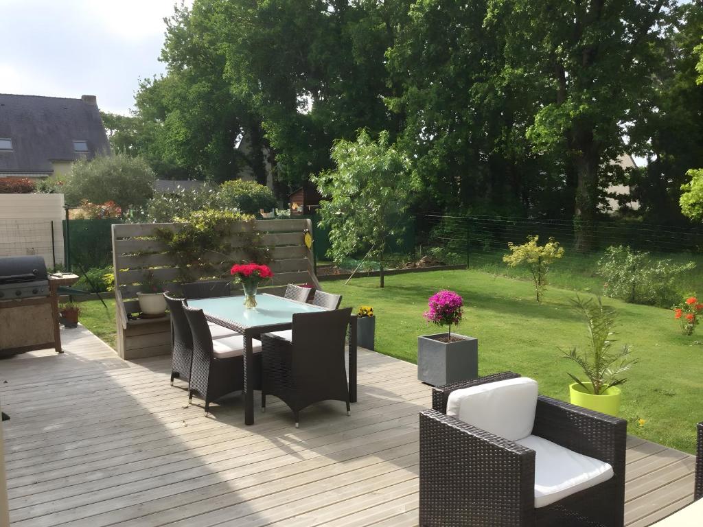 a patio with a table and chairs on a deck at Chambres d'Hôtes - Les Boubous in Saint-Nazaire
