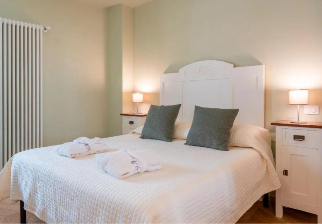 a bedroom with a white bed with towels on it at Casa Cennano in Montevarchi