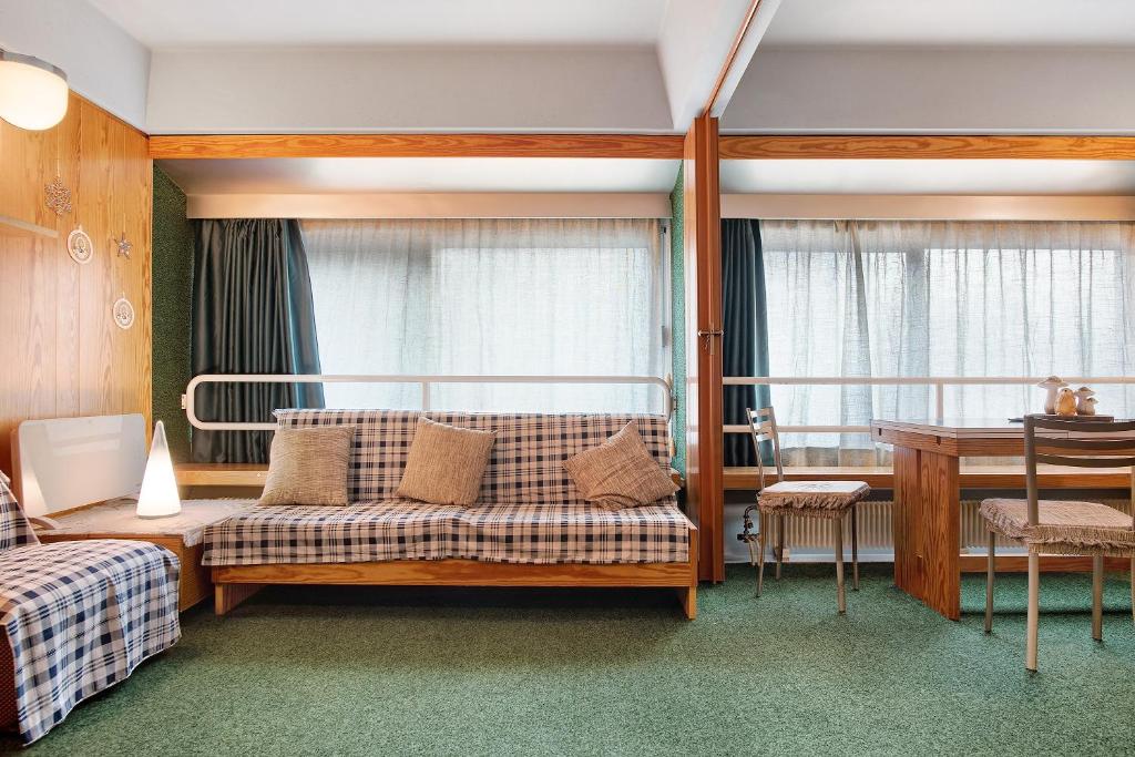 a bedroom with a bed and a table and a desk at Appartamento Nives in Marilleva