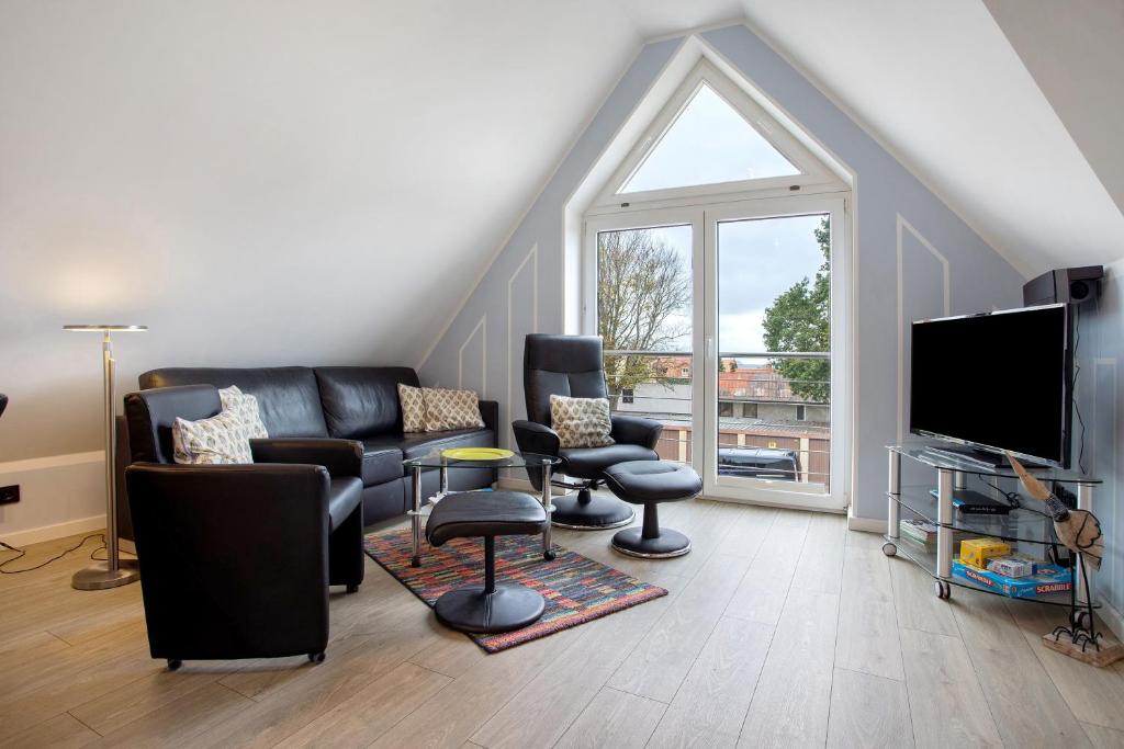 a living room with a couch and chairs and a tv at Bäckerhus - Ferienwohnung 4 in Wiek auf Rügen