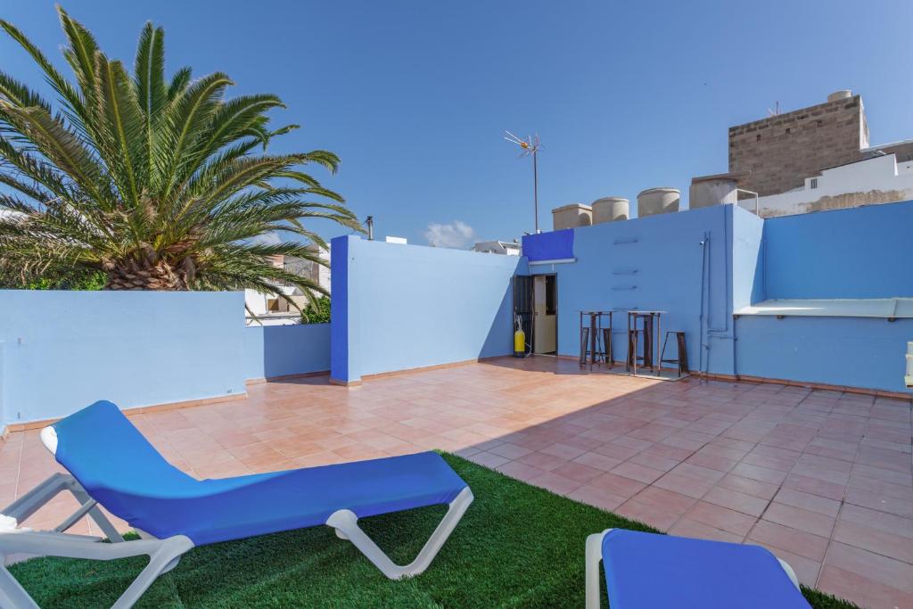 a patio with blue walls and chairs on a roof at Casa Mar Azul Arinaga in Arinaga